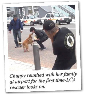 Chuppy reunited with her family at airport for the first time - LCA rescuer looks on.