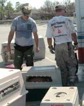 Chris DeRose and a Best Friends rescue worker load carriers into a truck.